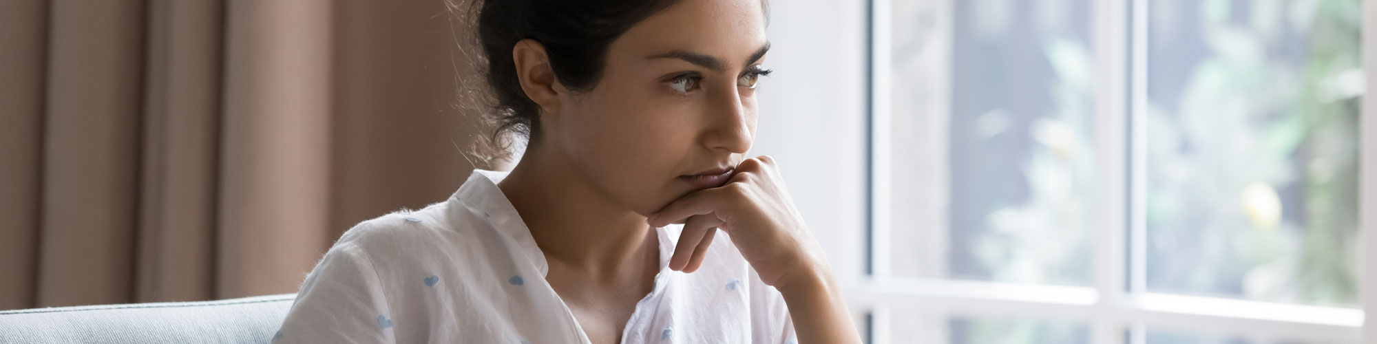 Sad Indian Woman Sit On Armchair Looks Concerned, Feels Confused