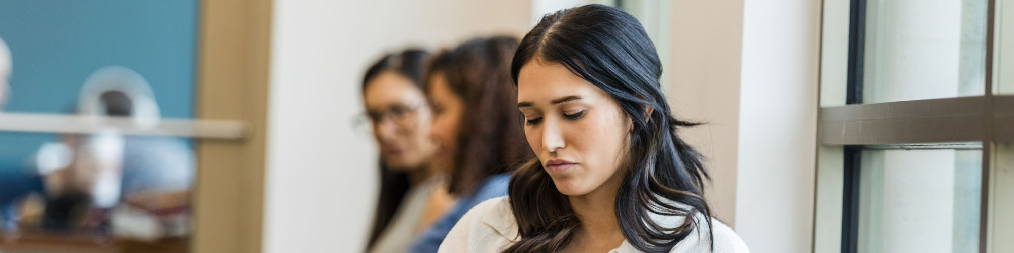 Young Woman Sitting Pensively In Waiting Room