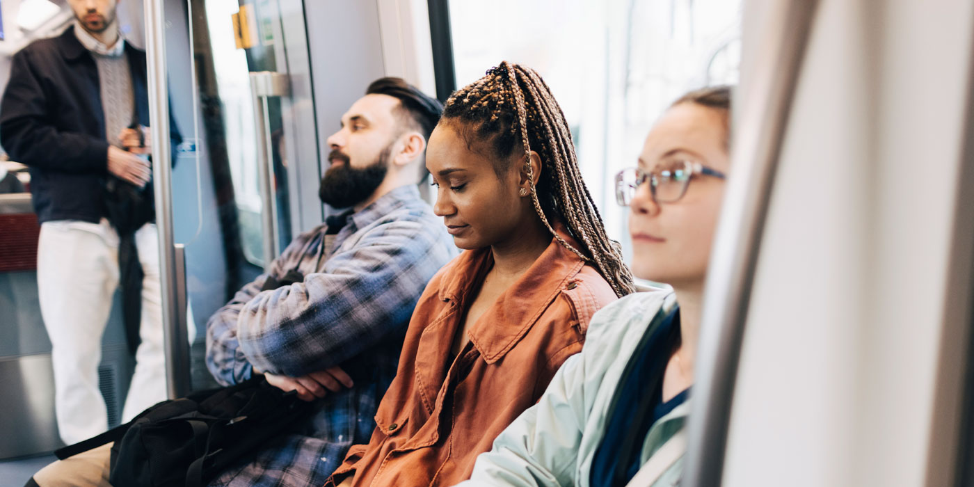 Male And Female Commuters Sitting Side By Side In Train Male And Female Commuters Sitting Side By Side In Train