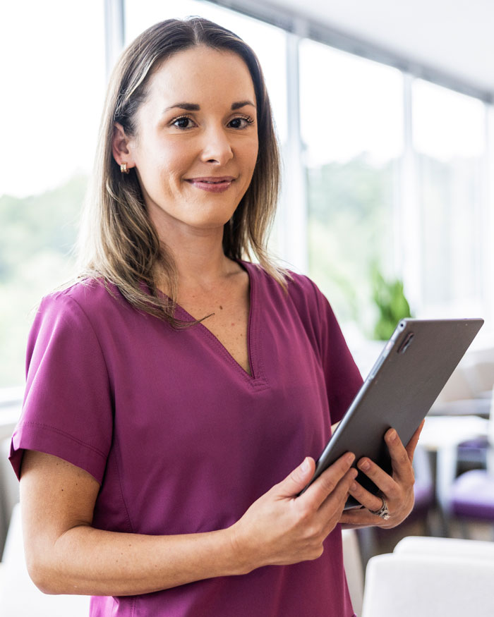 Portrait Of Female Nurse In Scrubs In Doctor's Office Portrait Of Female Nurse In Scrubs In Doctor's Office
