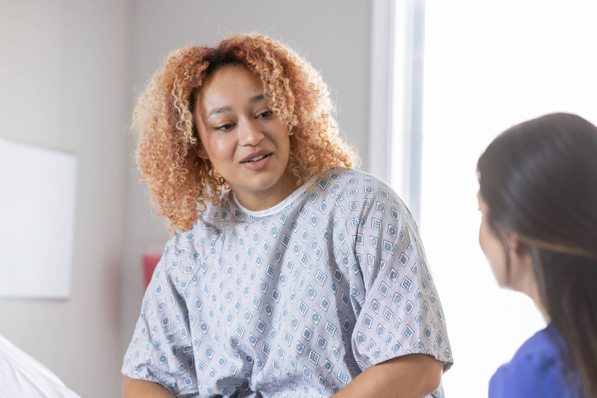 Woman Discusses Her Healthcare With Doctor In Hospital Woman Discusses Her Healthcare With Doctor In Hospital